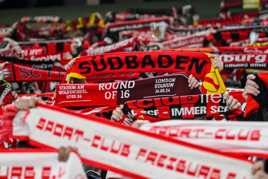 Fans von Freiburg halten vor dem Spiel ihre Schals hoch.  | Foto: Harry Langer (dpa)
